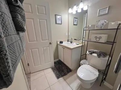 a bathroom with a white toilet and a sink at Americana at Emerald Island in Kissimmee