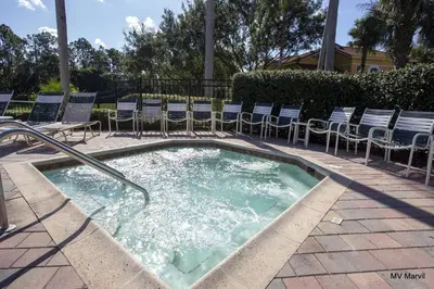 a hot tub with chairs and chairs in a courtyard at Americana at Emerald Island in Kissimmee