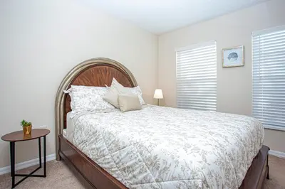 a bedroom with a large bed and a table at Floridian at Emerald Island in Kissimmee