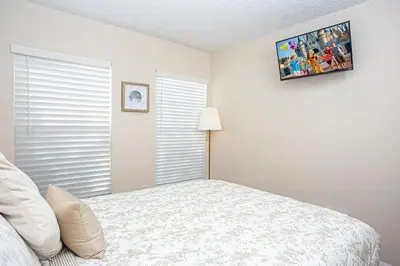 a bedroom with a bed and a tv on the wall at Floridian at Emerald Island in Kissimmee