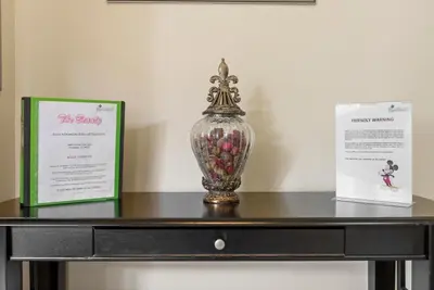 a glass vase sitting on a table with two certificates at The Beauty at Emerald Island in Kissimmee