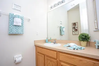 a bathroom with a sink and a large mirror at Bella Vista at Emerald Island in Kissimmee