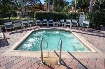 a small swimming pool with chairs in a courtyard at Meriggiare at Emerald Island in Kissimmee
