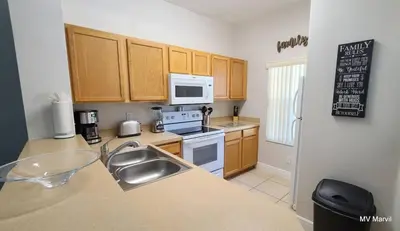a kitchen with a sink and a stove top oven at Asteria at Emerald Island in Kissimmee