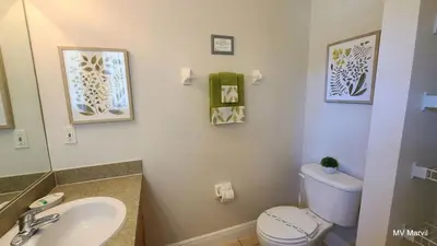 a bathroom with a sink and a toilet and a mirror at Asteria at Emerald Island in Kissimmee