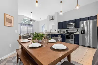 a kitchen with a wooden table with plates and wine glasses at Sunny Side Up in Orlando
