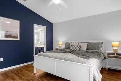 a bedroom with a bed and a blue wall at Sunny Side Up in Orlando