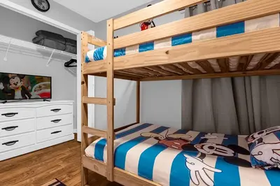 a bedroom with a bunk bed and a tv at Sunny Side Up in Orlando