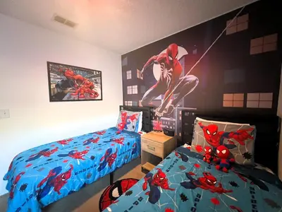 a bedroom with two beds and a spider man painting on the wall at The Haven in Kissimmee