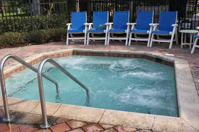 a jacuzzi tub with blue chairs and chairs at The Haven in Kissimmee