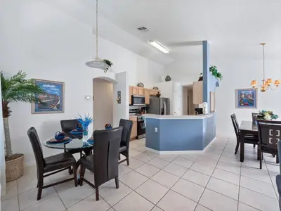 a dining room and kitchen with a table and chairs at Oasis Key Retreat by PropertyChekker! in Kissimmee