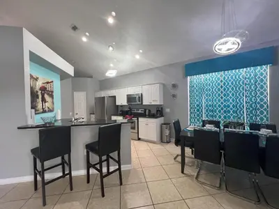 a kitchen and dining room with a table and chairs at Mickey's Castle by PropertyChekker! in Orlando