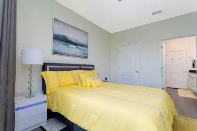 a bedroom with a bed with yellow pillows at Apartamento 2 Suítes no Cane Island Resort in Kissimmee