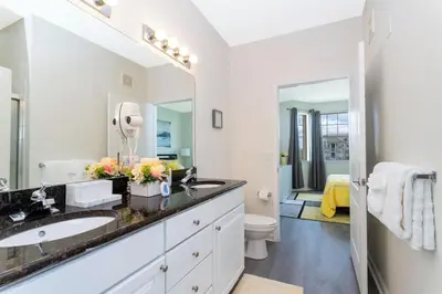 a bathroom with a sink and a toilet and a mirror at Apartamento 2 Suítes no Cane Island Resort in Kissimmee