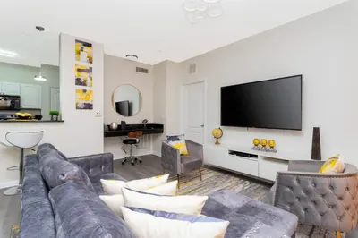 a living room with a couch and a flat screen tv at Apartamento 2 Suítes no Cane Island Resort in Kissimmee