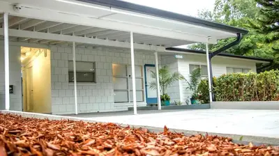 a white building with awning and a pile of leaves at Orlando Villa: Pool Garage & Garden View in Orlando