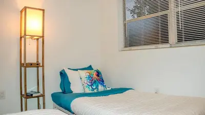 a white bedroom with a bed and a window at Orlando Villa: Pool Garage & Garden View in Orlando