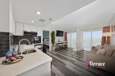 a kitchen and living room with a couch and a table at Gorgeous 2 Bed 2 Bath Flamingo Penthouse Volcano Bay View in Orlando