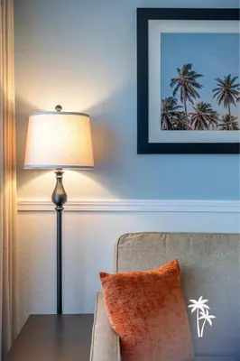 a lamp sitting next to a table with a chair at Relaxing 2 Bed 2 Bath Condo with Garden View Balcony 7 Min to Universal in Orlando