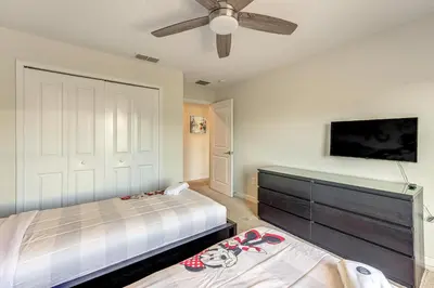 a bedroom with two beds and a flat screen tv at Lanai and Private Pool, 8 Mi to WDW Family Getaway! in Kissimmee