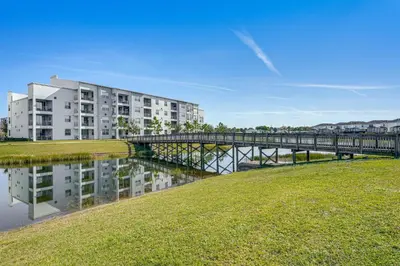 a bridge over a body of water with a building at Lanai and Private Pool, 8 Mi to WDW Family Getaway! in Kissimmee