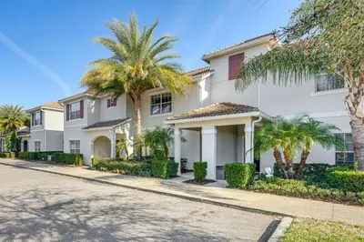 a white house with palm trees and a street at Lanai and Private Pool, 8 Mi to WDW Family Getaway! in Kissimmee