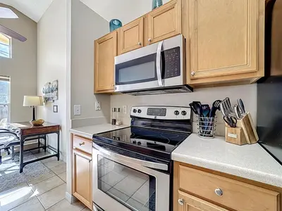 a kitchen with a stove and a microwave at Emerald Island Disney Villa with Pool & Spa in Kissimmee