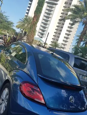 a blue car parked in a parking lot with palm trees at Blue Heron Beach Resort 1-809 in Orlando