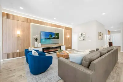 a living room with a large couch and blue chairs at Casa 12Q no Paradiso Grande, perto da Disney in Orlando