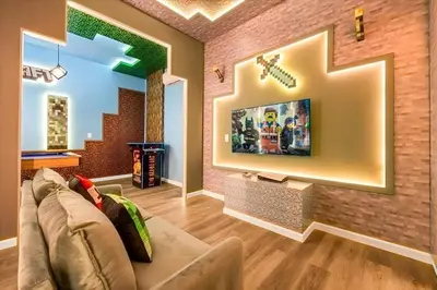 a living room with a couch and a tv on a brick wall at Casa 12Q no Paradiso Grande, perto da Disney in Orlando