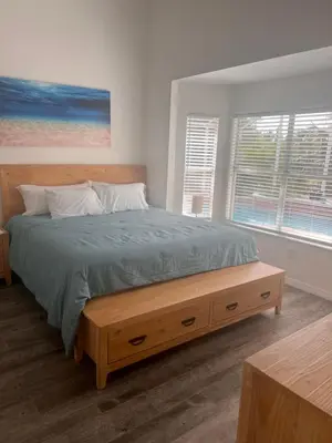 a bedroom with a large bed with a wooden headboard at Woodland Yard in Kissimmee