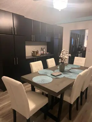 a dining room with a wooden table and white chairs at Woodland Yard in Kissimmee