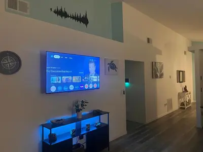 a living room with a flat screen tv on a wall at Woodland Yard in Kissimmee