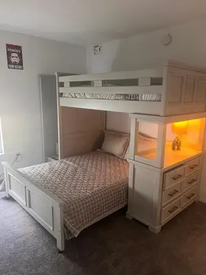 a bedroom with two bunk beds and a dresser at Woodland Yard in Kissimmee
