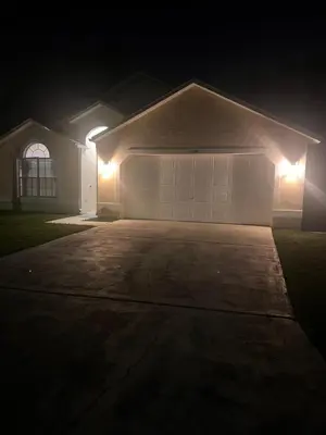 a house with a garage at night with lights at Woodland Yard in Kissimmee