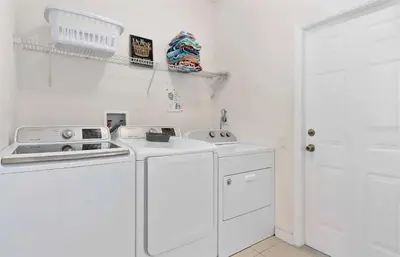 a white kitchen with a stove and a sink at Themed Windsor Hills 6BR Private Pool Gameroom in Orlando