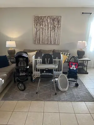 a living room with three baby strollers and a couch at Themed Windsor Hills 6BR Private Pool Gameroom in Orlando