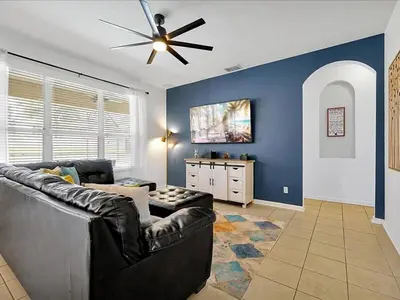 a living room with a couch and a ceiling fan at Themed Windsor Hills 6BR Private Pool Gameroom in Orlando