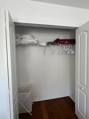 a white closet with a shelf and a door at The Mahal in Sanford