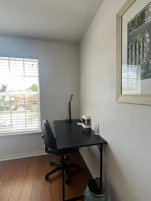 a desk with a chair in a room with a window at The Mahal in Sanford