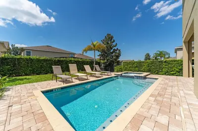 a swimming pool with chairs and a house at Amazing Stay 10 min from Disney in Orlando