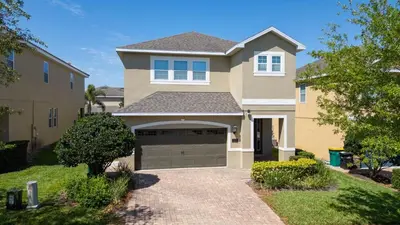 a large house with a garage in a yard at Amazing Stay 10 min from Disney in Orlando