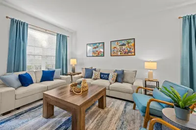a living room with a couch and a table at 6 BR Home, Themed Rooms, Private Pool, Windsor Hills by Blue Sky Villas in Orlando