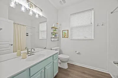 a white bathroom with a sink and a toilet at 6 BR Home, Themed Rooms, Private Pool, Windsor Hills by Blue Sky Villas in Orlando