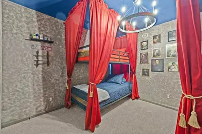 a bedroom with a bed with red curtains at 6 BR Home, Themed Rooms, Private Pool, Windsor Hills by Blue Sky Villas in Orlando