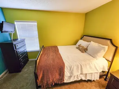 a bedroom with a bed with a cat laying on it at Spacious 7BR Retreat w Pool & Jacuzzi V#202 in Kissimmee