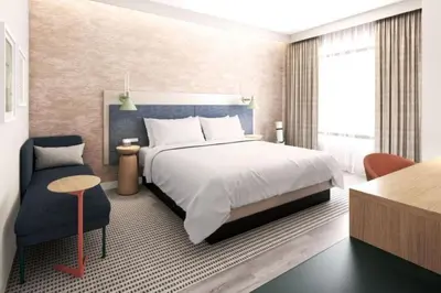 a bedroom with a large bed and a chair at EVEN Hotel Orlando Universal Blvd by IHG in Orlando