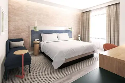 a bedroom with a large bed and a chair at EVEN Hotel Orlando Universal Blvd by IHG in Orlando