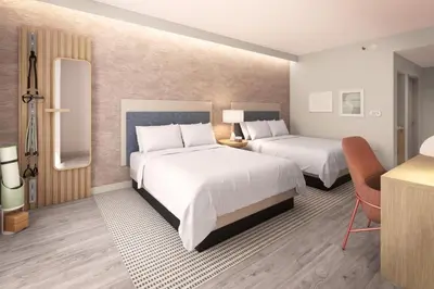 a hotel room with two beds and a desk at EVEN Hotel Orlando Universal Blvd by IHG in Orlando