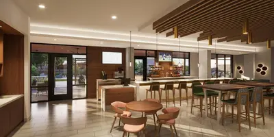 a kitchen with tables and chairs and a bar at Staybridge Suites Orlando Universal Blvd by IHG in Orlando